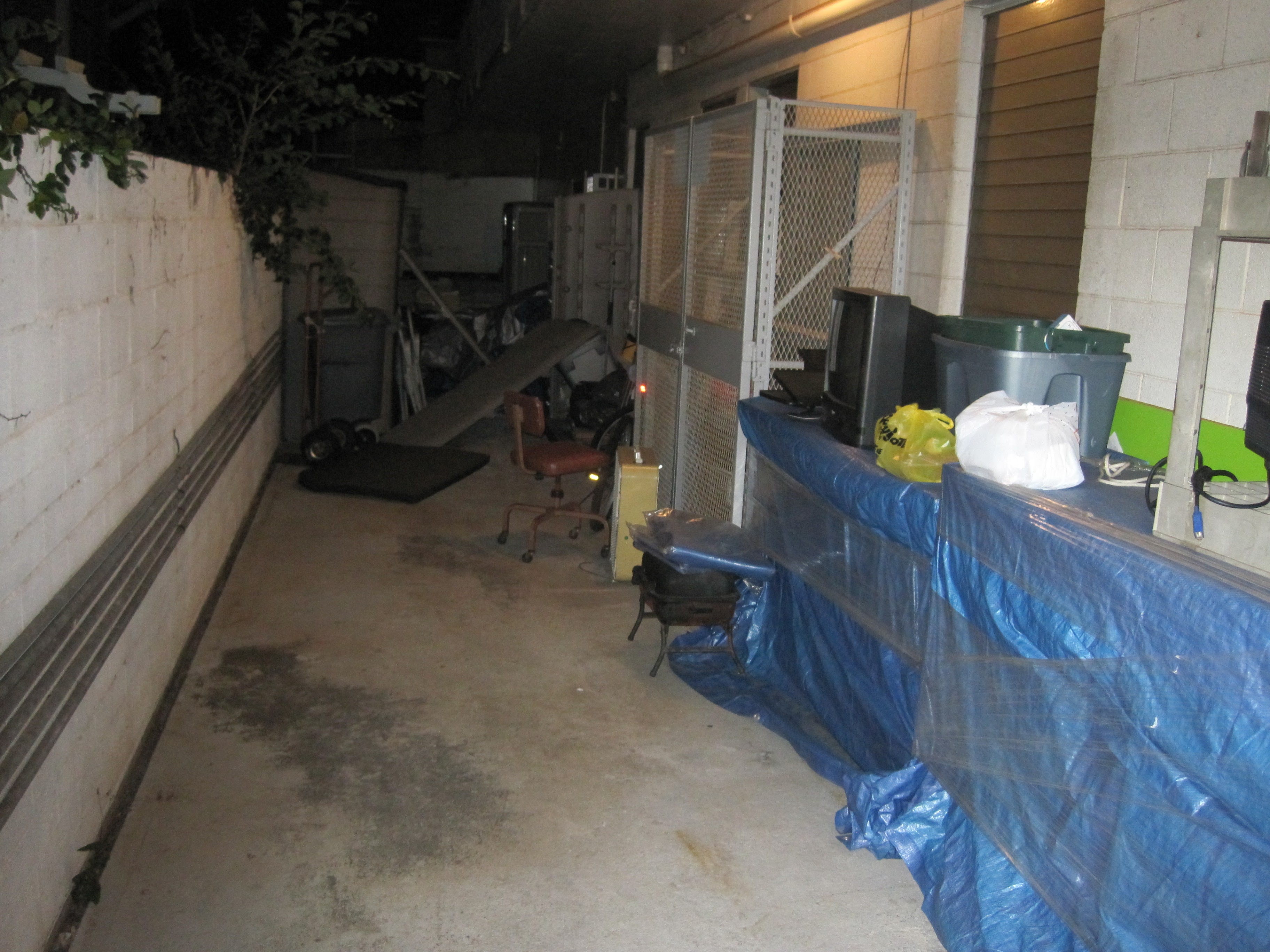 Alleyway cluttered with tarps and stored items